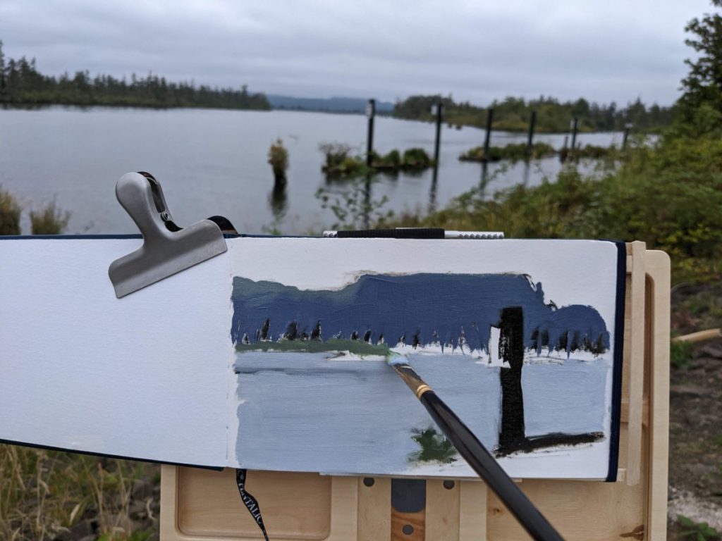 Example of painting in a sketchbook on location at a dock next to a river